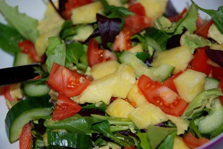 Sallad med avocado, färsk ananas, tomater, gurka och blandad sallad.