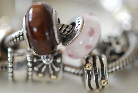 Ett par färgade berlocker. Rosa och brunt..