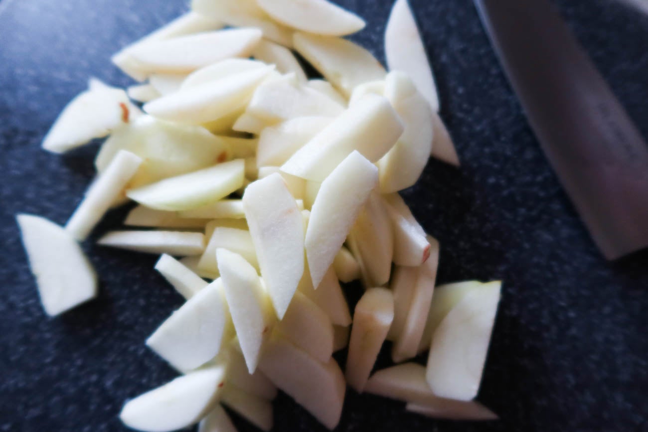 Äppelklyftor nedtryckta i kaksmet till äppeltosca