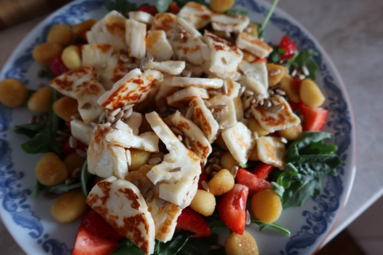 Närbild på halloumisallad med stekt gnocchi och honungsdressing