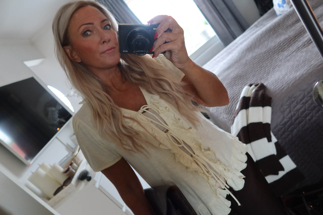 Närbild på outfit med topp och byxor