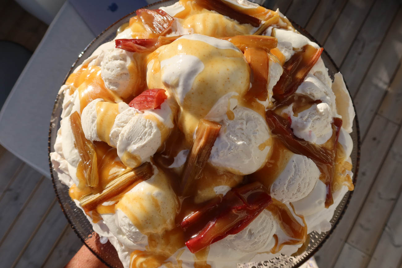 Pavlova med grädde, glass och rabarber redo att serveras