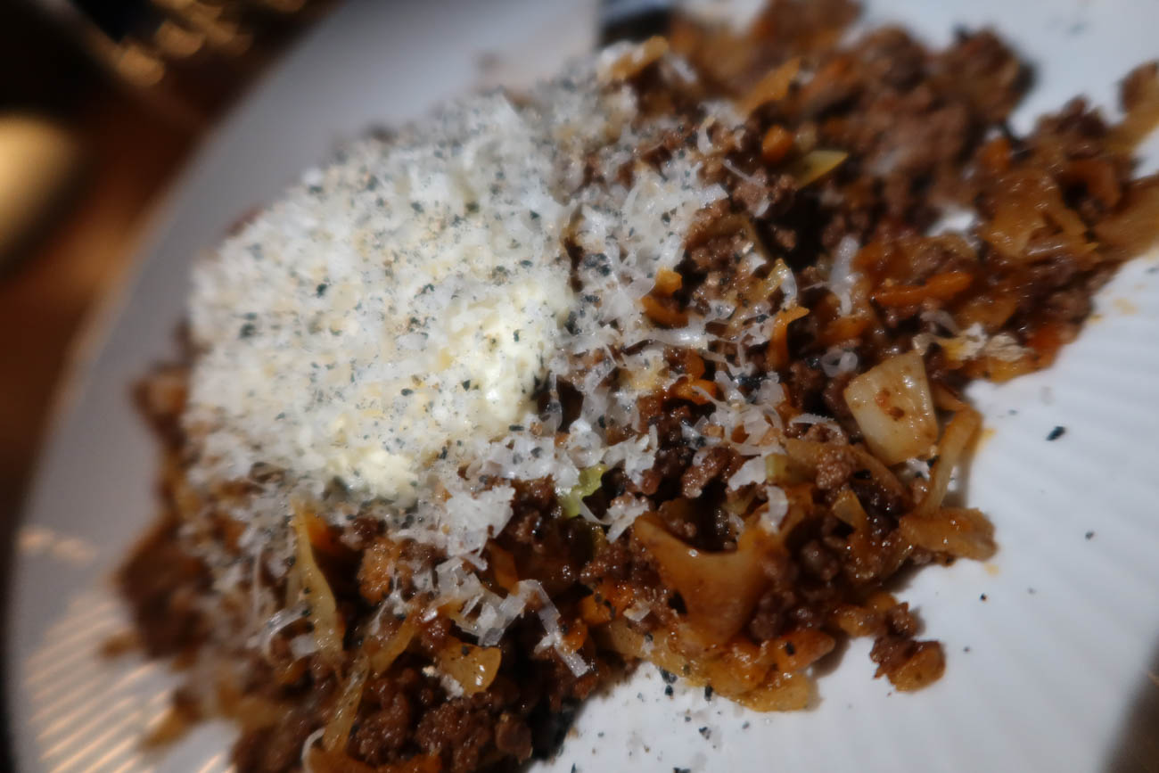 Köttfärs och vitkålsfräs serverat med smetana och parmesan