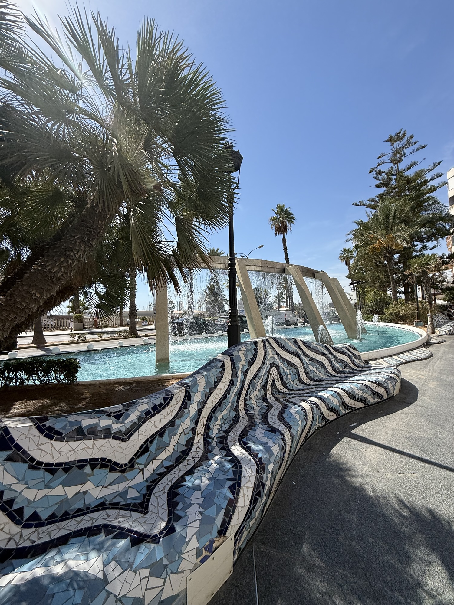 Sandstrand med strandväskor och parasoll