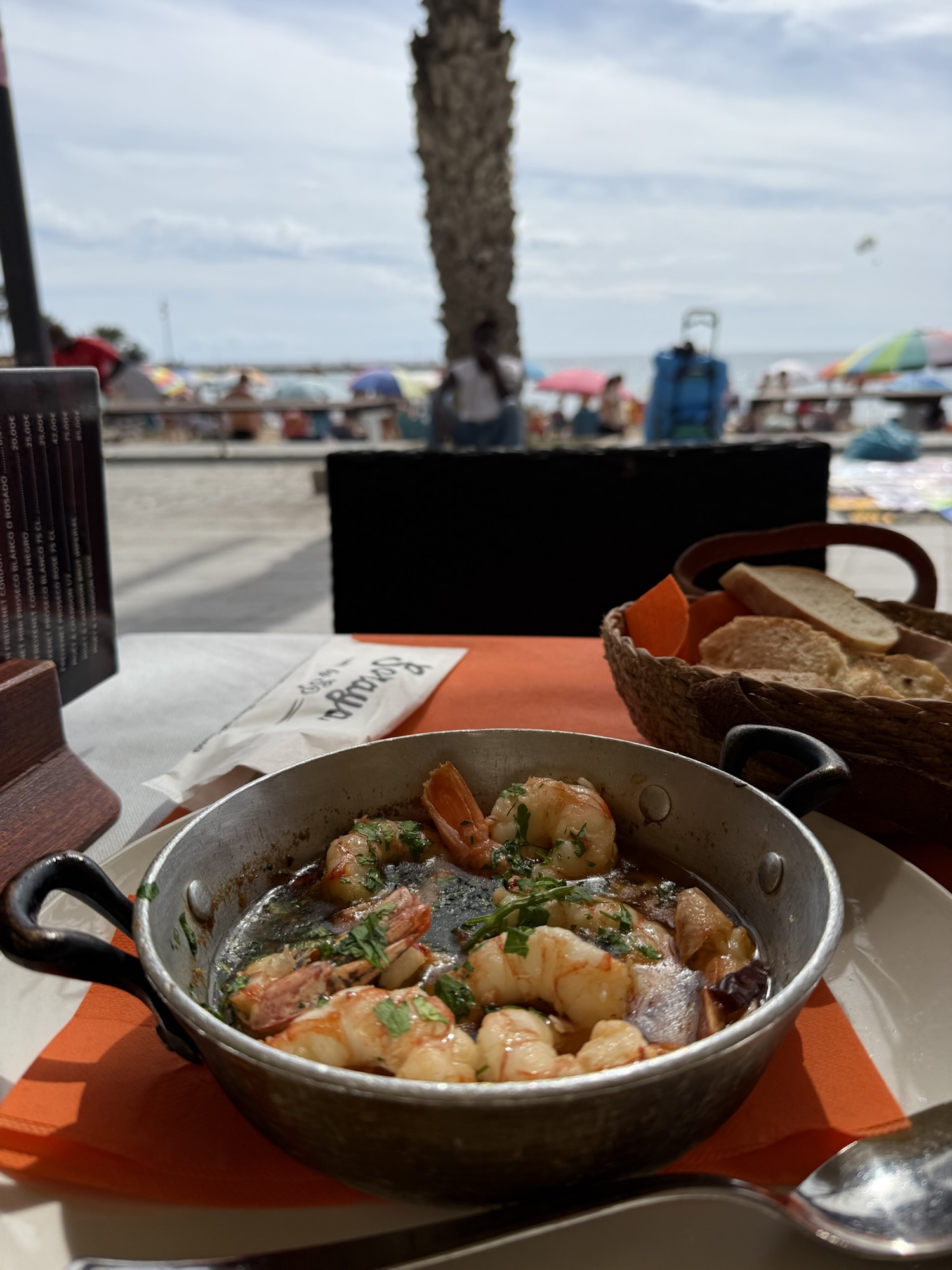 Sangria och tapasbord under parasoll vid havet