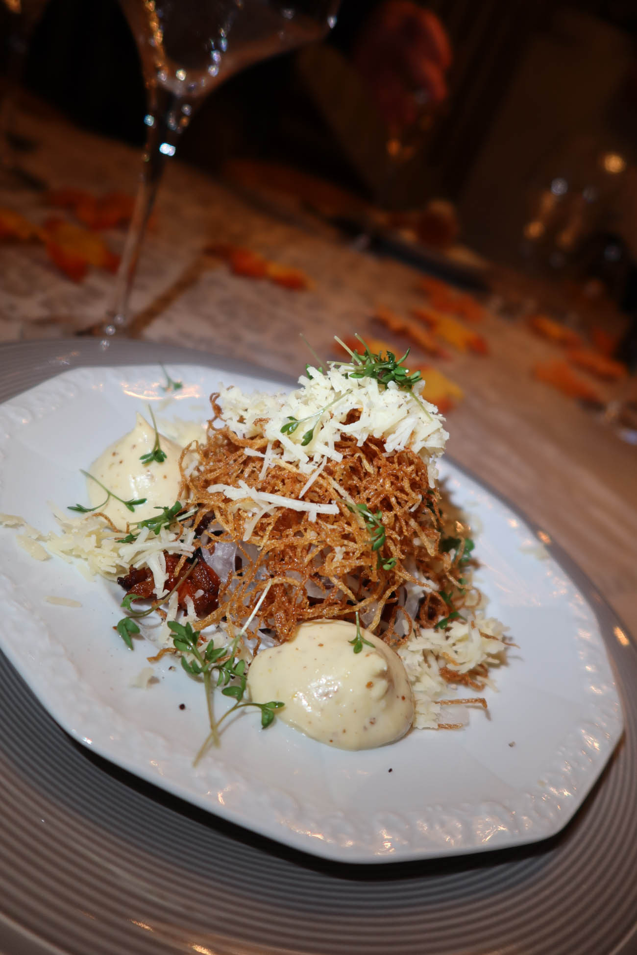 Tomattartar med senapsmajonnäs serverad på tallrik med krasse och potatiskrisp