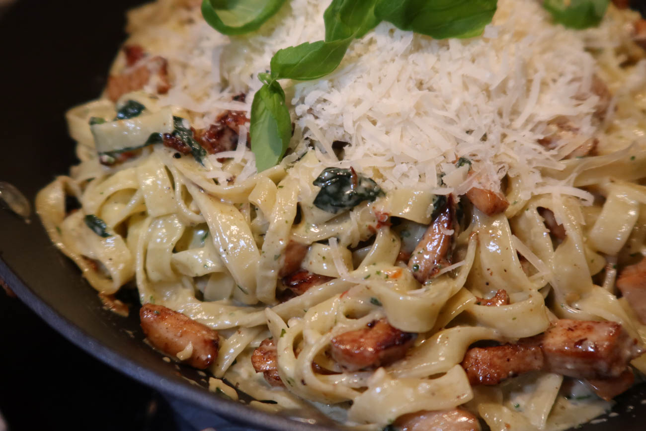 Närbild på linguine med kyckling, pesto och parmesan