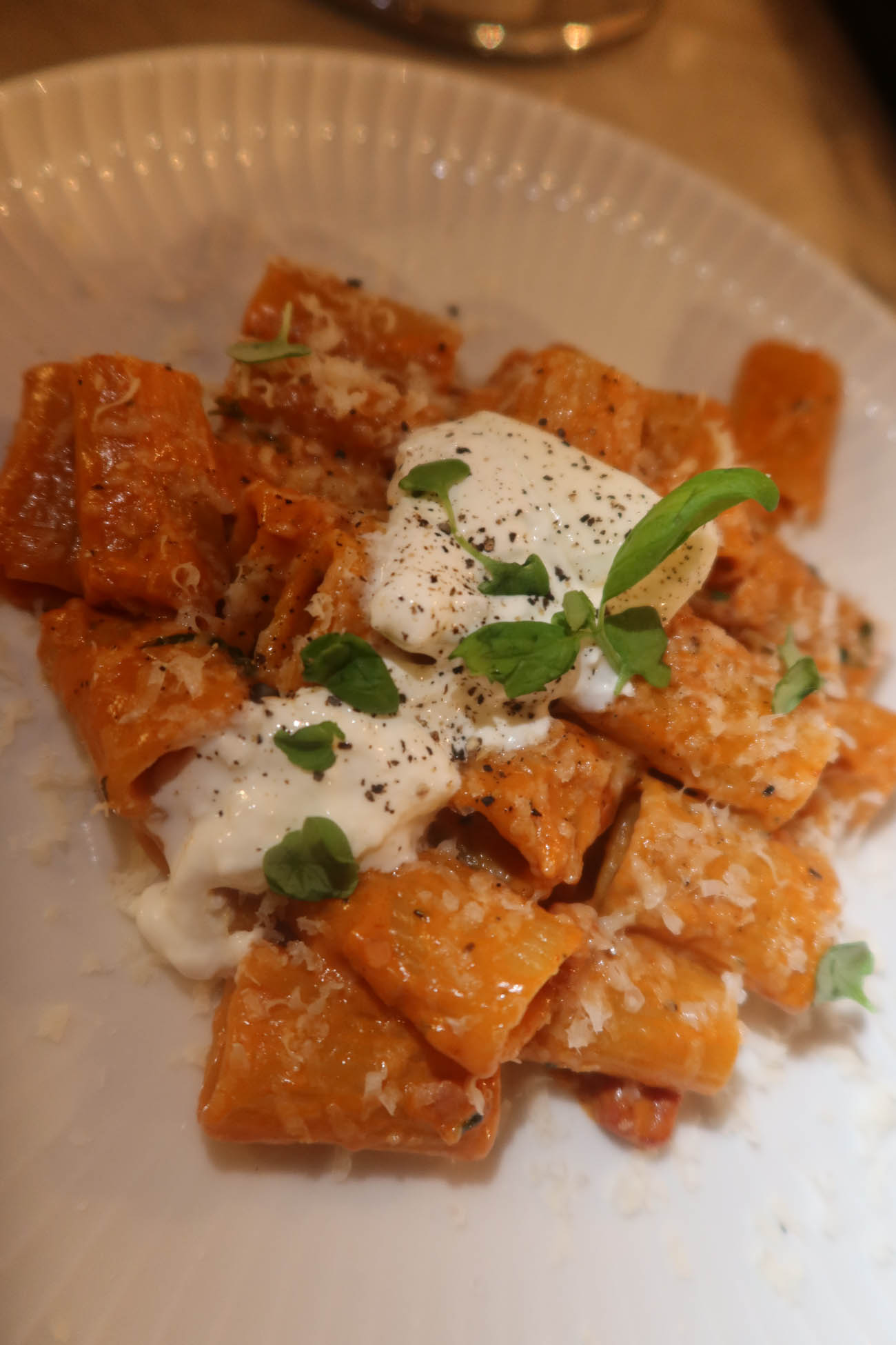 Krämig vodkapasta med parmesan och basilika serverad i djup tallrik
