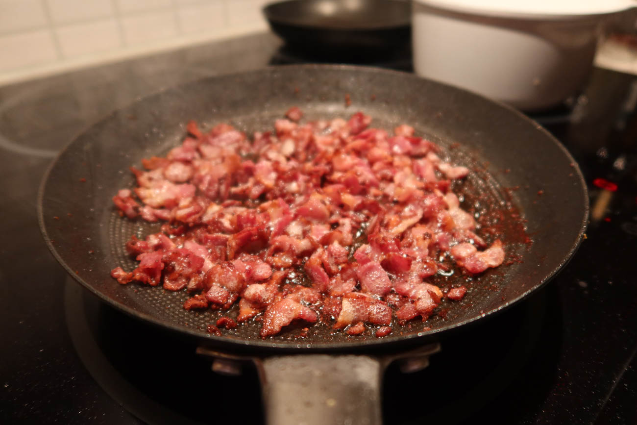 Baconsylt som kokar och karamelliseras i kastrull